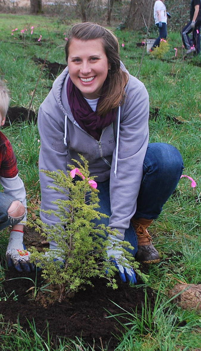 Nicole planting native trees and shrubs with local K-12 students in Portland, Oregon.
