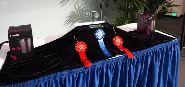 The ribbons, glass trophy, and Sonos speakers are displayed onstage. Credit: Patricia Marroquin